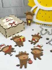 Яркие новогодние игрушки на елку с изображением символа года в деревянной коробке