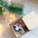 Яскраві новорічні іграшки на ялинку в подарунковій коробці з дерева